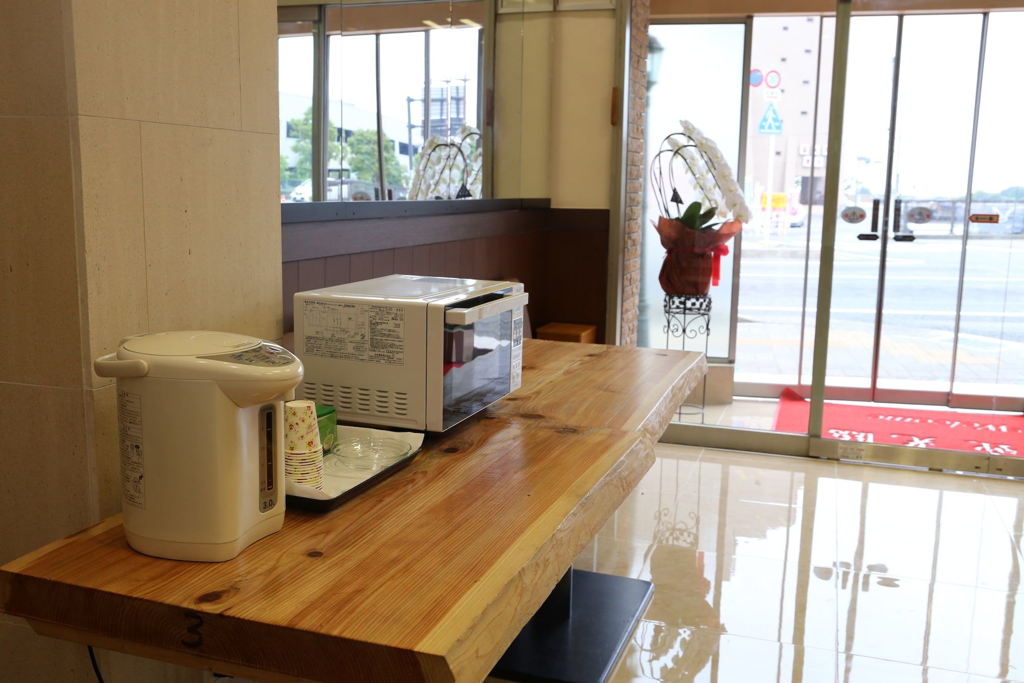 Una encimera de cocina con microondas, cafetera y refrigerador pequeño.