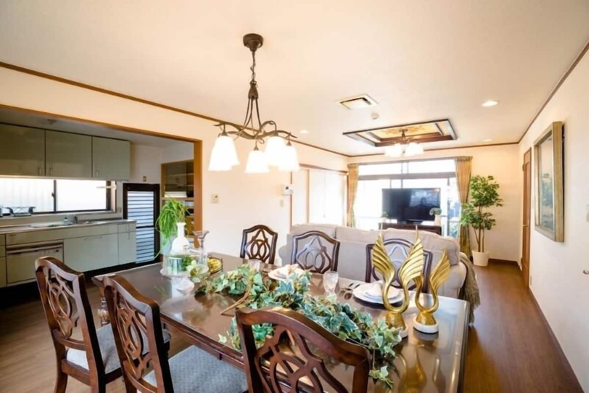 Un coin repas avec une table en bois, des chaises et un lustre.