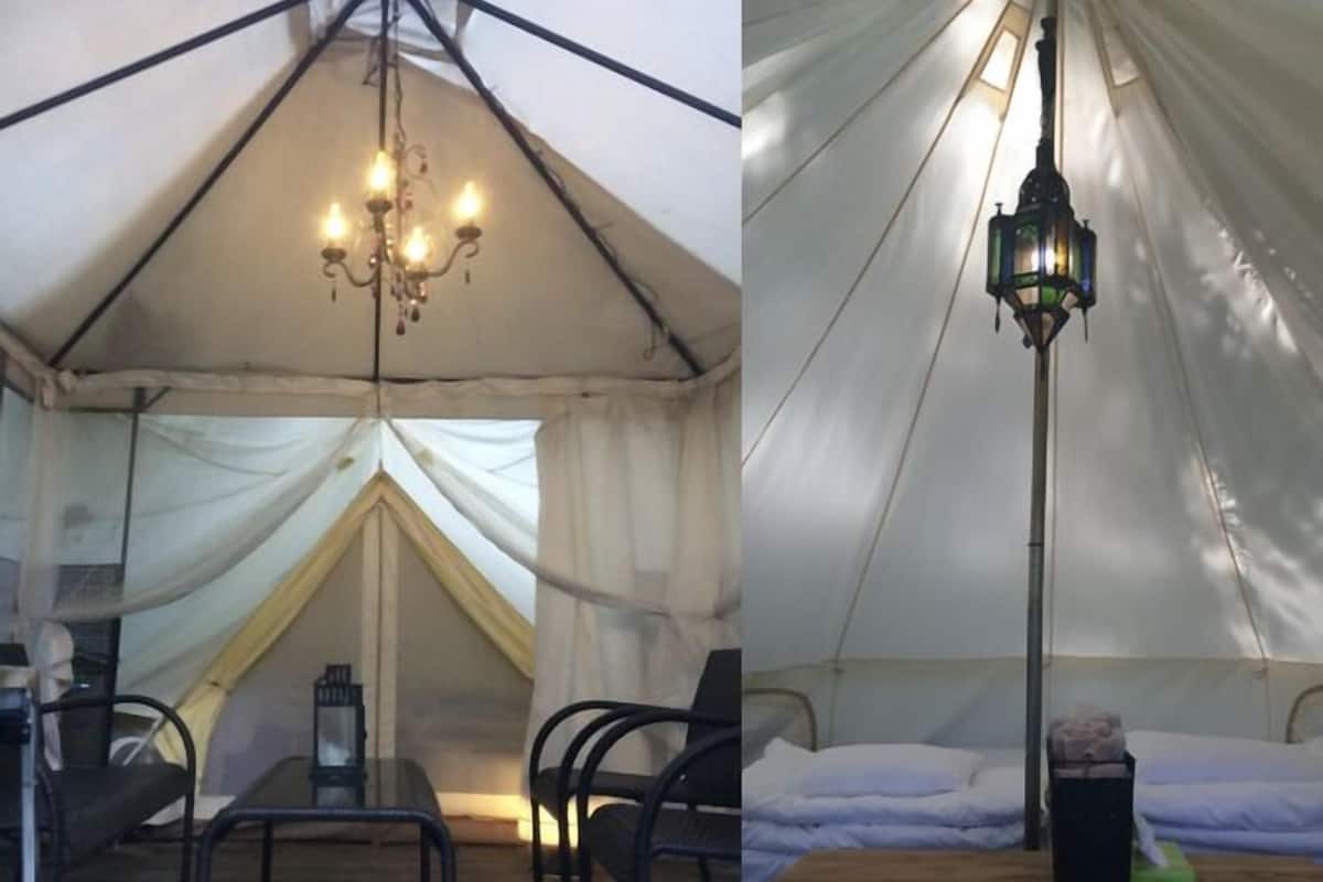 Una carpa con un candelabro, un farol y una cama con almohada.