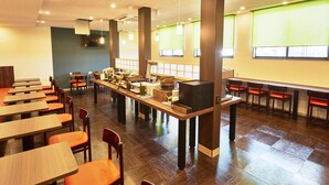 A spacious dining area with multiple tables and chairs, a buffet setup, and large windows with blinds. - Hotel Kan-raku Honjo Waseda Ekimae (Honjo)