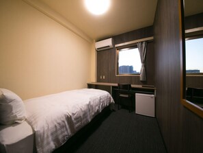 A hotel room with a bed, desk, chair, air conditioning unit, and a window with a view. - Hotel 910 (Oita)