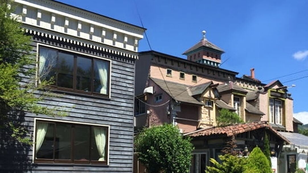A building with a traditional architectural style, featuring a prominent tower and a large window.