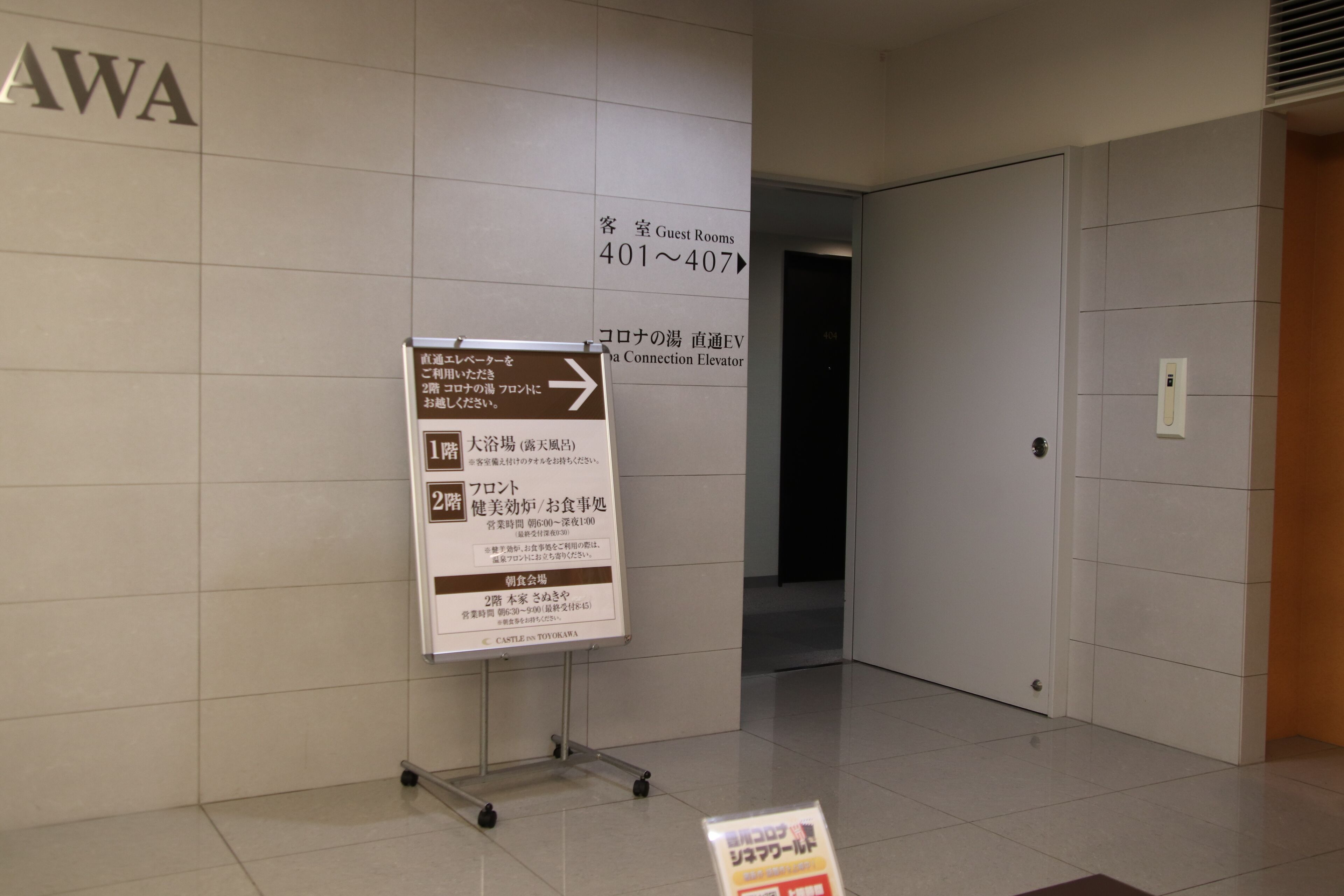 A hotel corridor with directional signs indicating guest rooms and amenities.