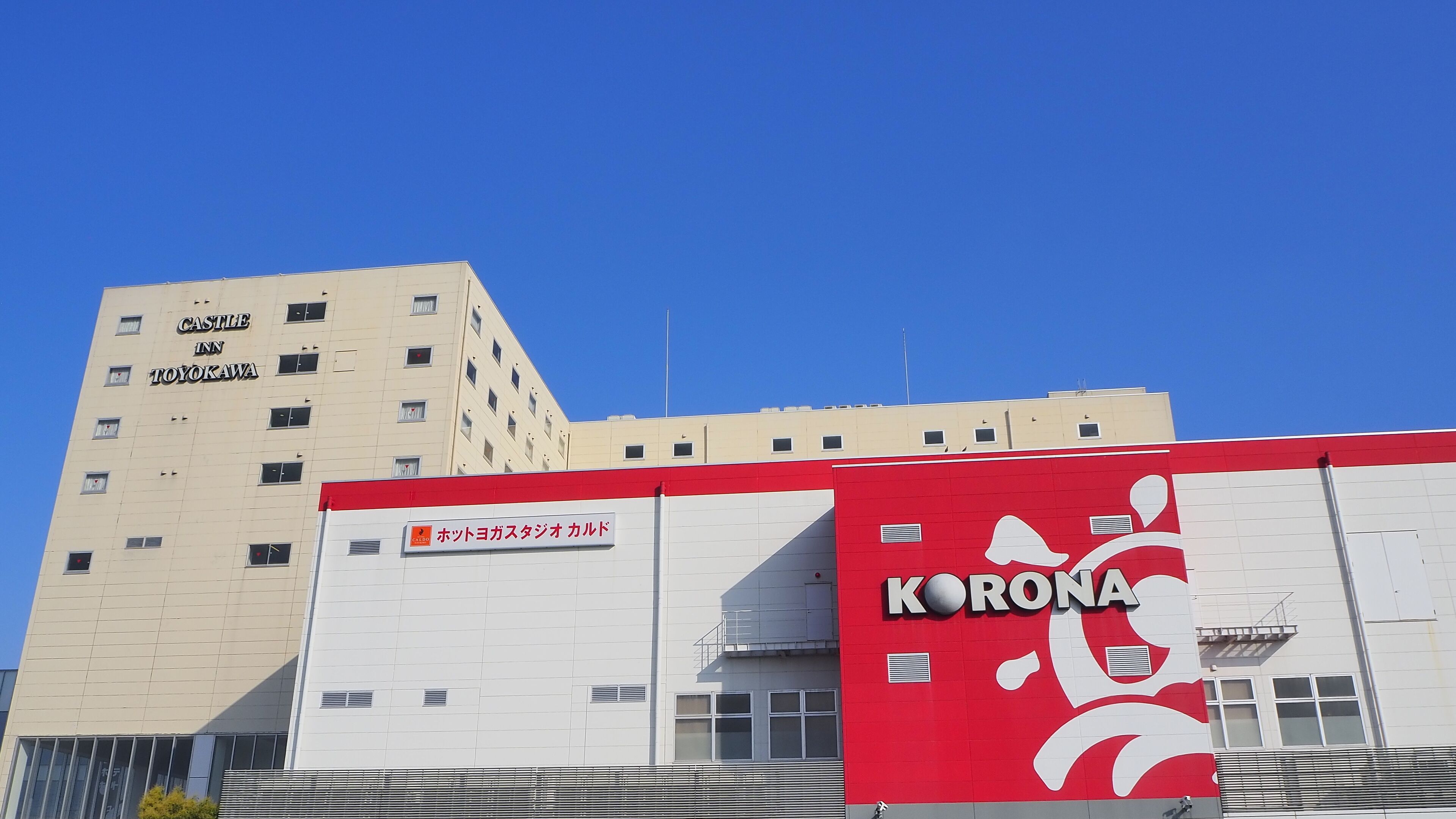 A hotel named Castle Inn in Toyokawa with a red and white sign for Corona.