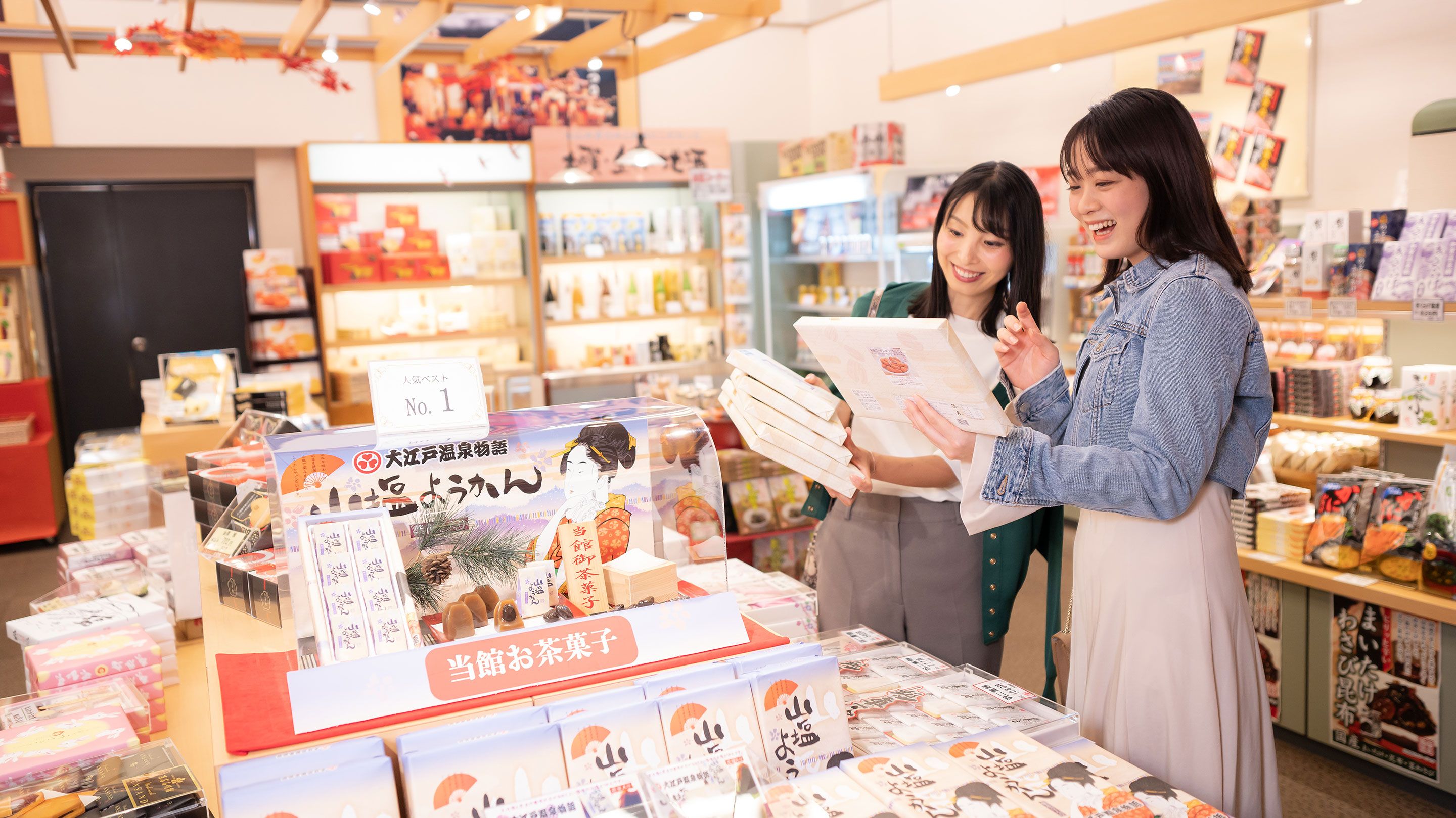 A bookstore with shelves stocked with books and a display table with book covers.