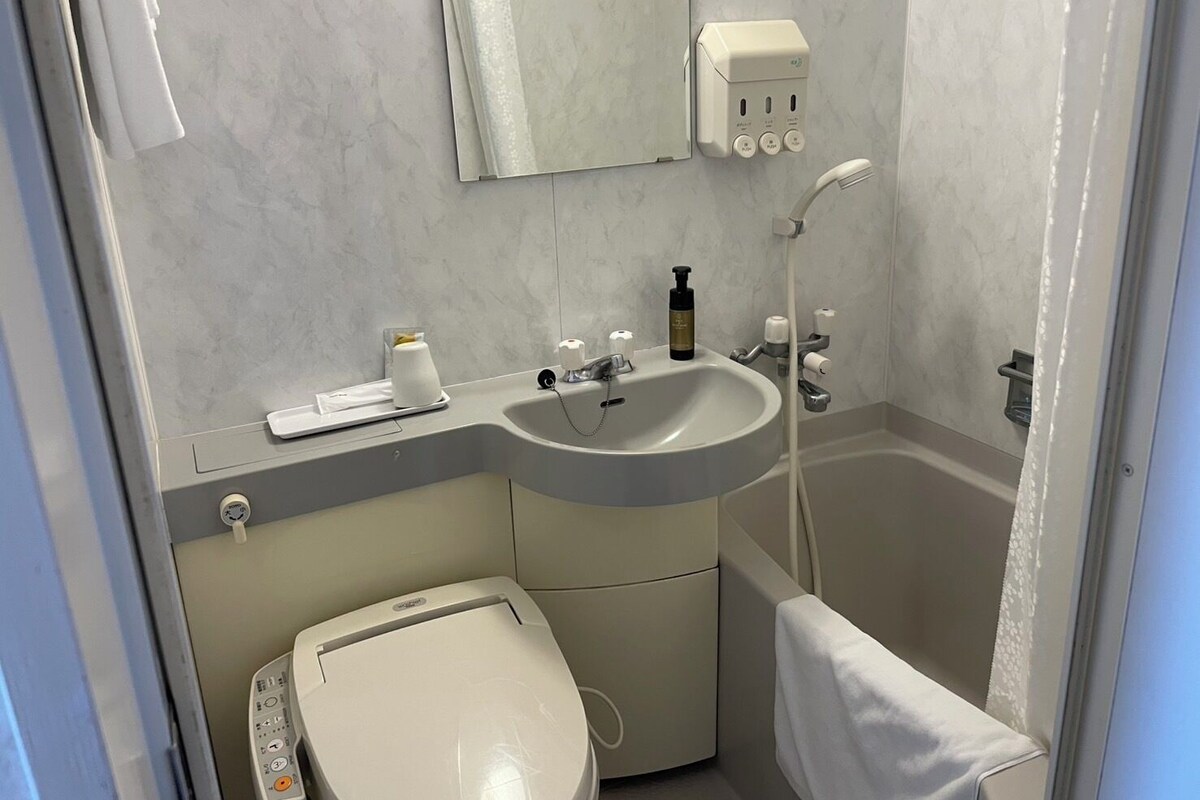 A bathroom with a sink, toilet, and shower.