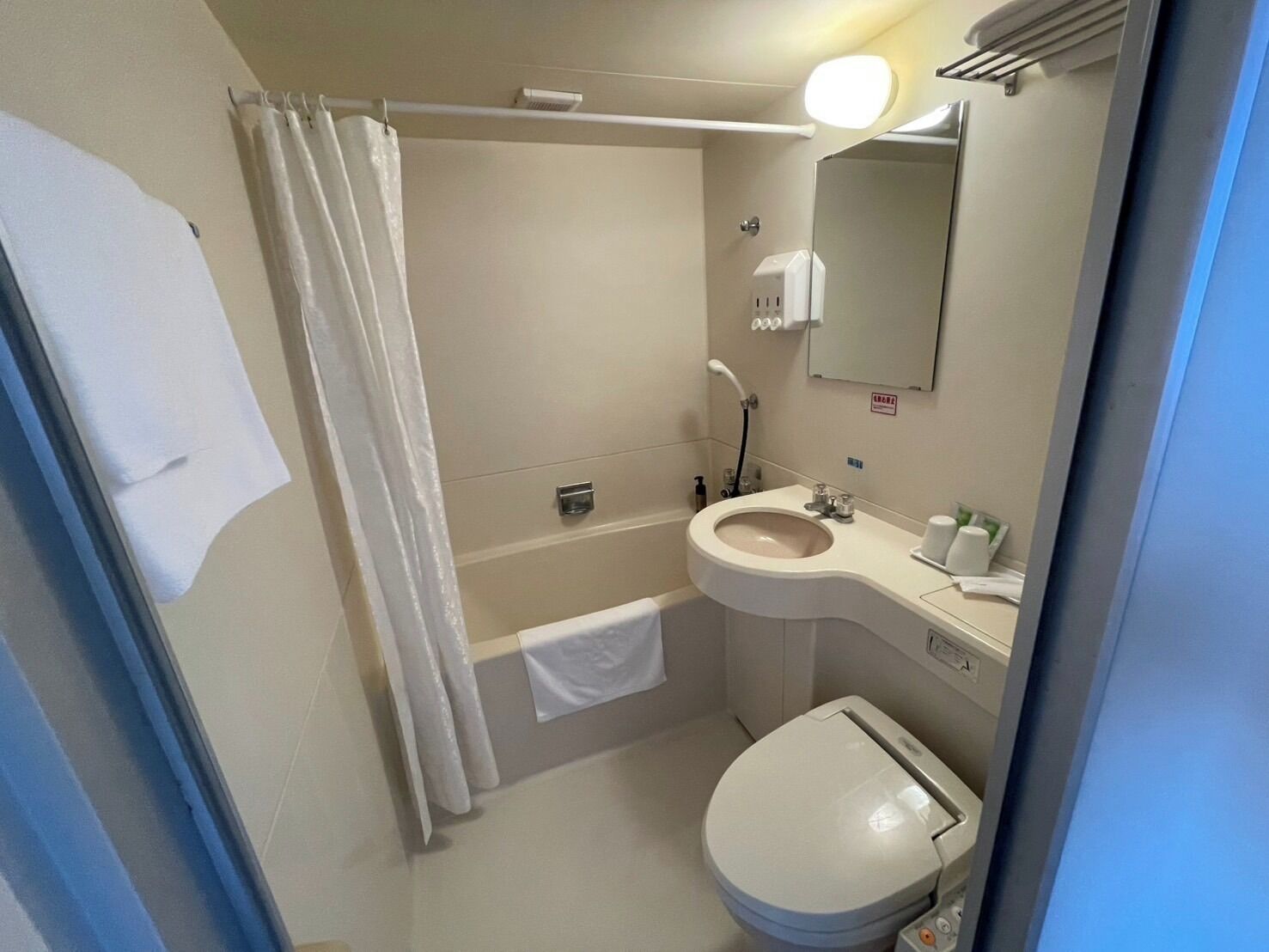 Un baño con inodoro, lavabo y zona de ducha.