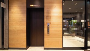 An elevator with a wooden panel design, a floor information sign, and a glass door entrance. - Super Hotel Okayama Eki Higashiguchi Hot Spring (Okayama)