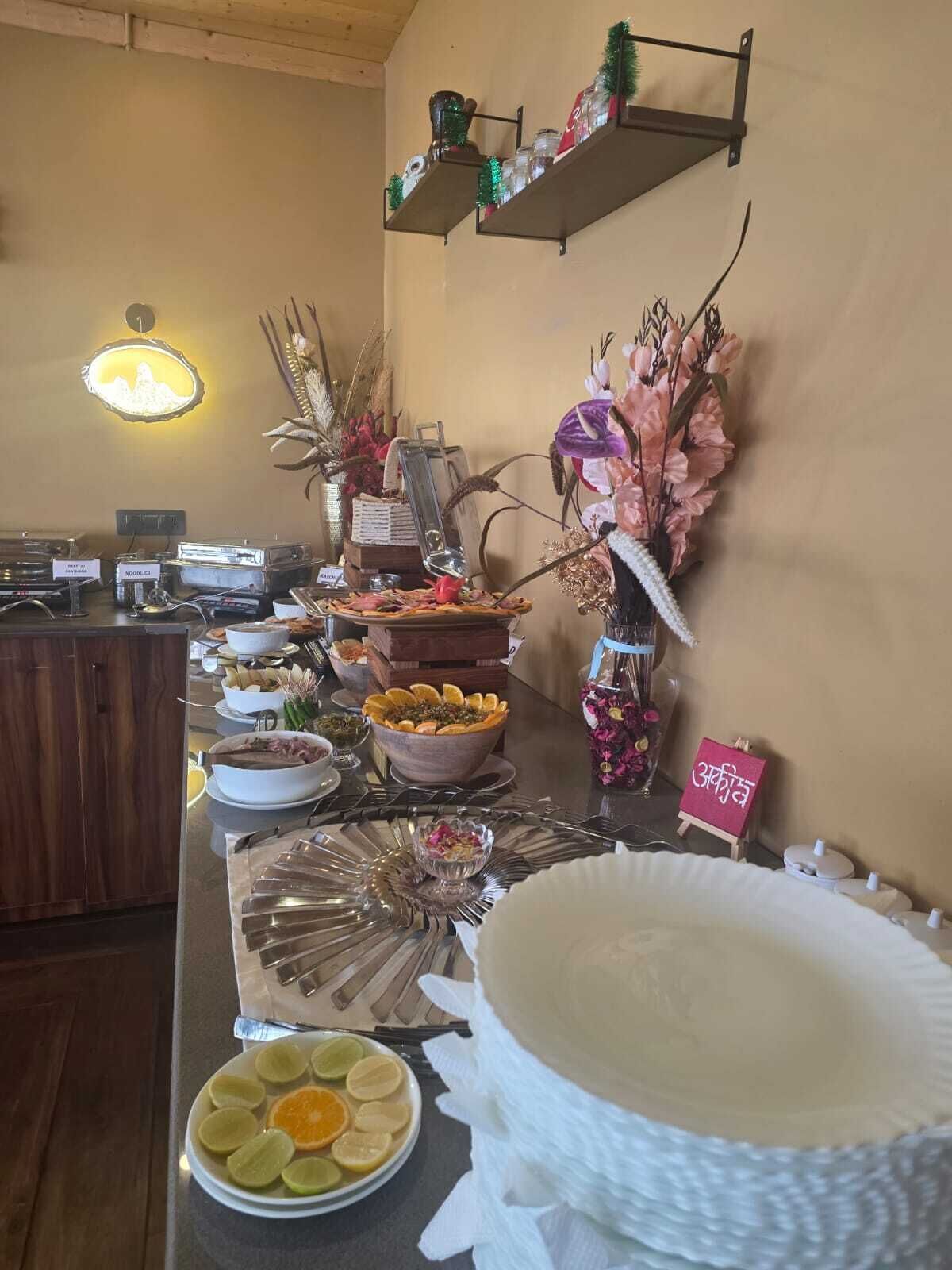 A buffet setup with various food items and a decorative vase.