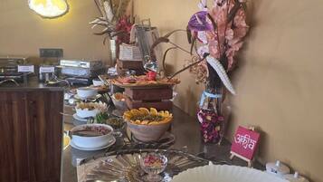 A buffet setup with various food items and a decorative vase.
