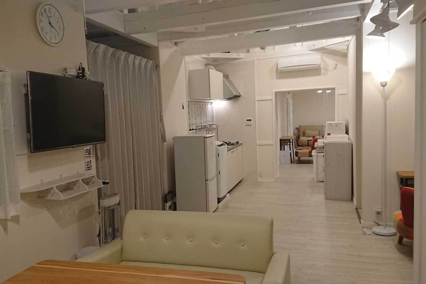 A compact living space with a television, kitchenette, and a dining area.