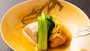 Eine Schüssel mit einem Gericht, möglicherweise einem Knödel, und Gemüse.