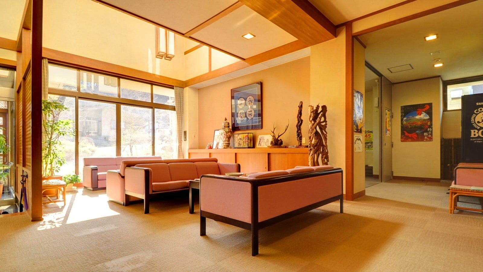A spacious lobby with a reception desk, seating area, and large windows allowing natural light.
