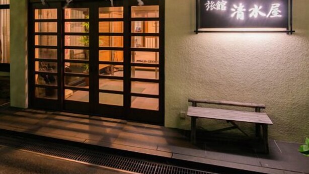 A building entrance with a large glass door, a bench outside, and a sign with Chinese characters. - Nasuyumoto Onsen Ryokan Shimizuya (Nasu)