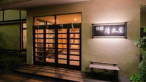 A building entrance with a wooden door and a bench outside. - Nasuyumoto Onsen Ryokan Shimizuya (Nasu)