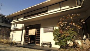 A building with a flat roof, a wooden bench outside, and a sign with Japanese characters. - Nasuyumoto Onsen Ryokan Shimizuya (Nasu)