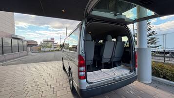 A van parked at a gas station with its rear door open, revealing the interior.