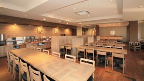 A spacious restaurant with wooden tables and chairs, a counter with kitchen appliances, and a modern ceiling design. - Hotel Route-inn Natori Iwanuma Inter (Iwanuma)