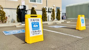 Área de estacionamento com pontos de carregamento EV 200V, indicada por placas amarelas.