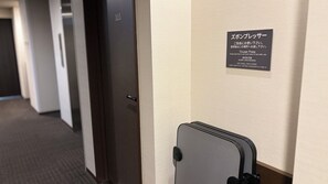 A hotel room with a door marked with the number 101, a sign with instructions in Japanese, and a suitcase against the wall. - Hotel Route-inn Natori Iwanuma Inter (Iwanuma)