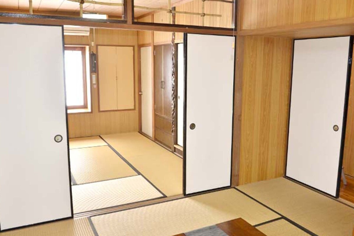 A traditional Japanese-style room with tatami flooring, sliding doors, and a wooden interior.