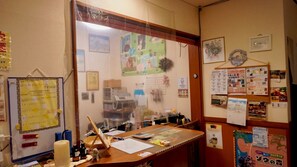 Una taulell de recepció amb un tabló d'anuncis, un calendari i diversos avisos.