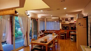 A cozy, well-lit room with a dining table, chairs, and a kitchen area. - Pension Twilight (Nasu)