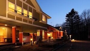 A two-story house with a covered porch and a small deck area. - Pension Twilight (Nasu)