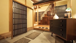 A traditional Japanese interior with tatami flooring, a sliding door, a wooden staircase, and a dresser with drawers. - Araiya (Tokyo)