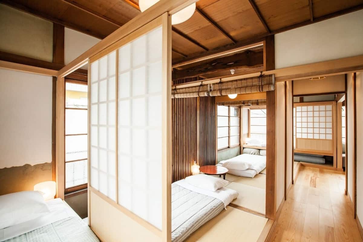 Een traditionele Japanse kamer met tatami vloerbedekking, schuifdeuren en een laag plafond.