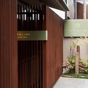 A modern building facade with a wooden panel design and a sign for Tassel Inn Kawaramachi Niijo. - Tassel Inn Kyoto Kawaramachi Nijo (Kyoto)