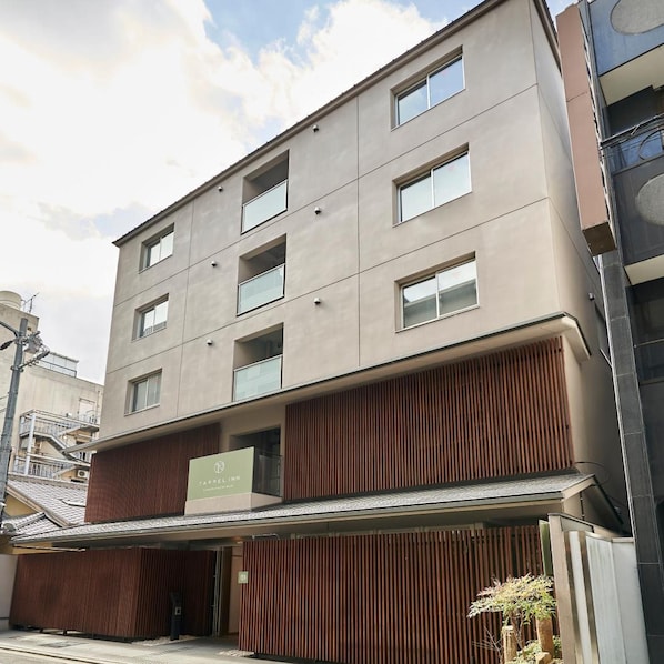 A multi-story building with a flat facade, several windows, and a sign for 'TASSEL INN' indicating it is a hotel. - Tassel Inn Kyoto Kawaramachi Nijo (Kyoto)