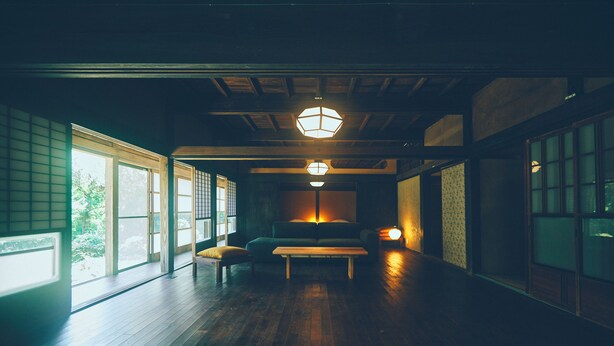 Une pièce de style japonais traditionnel, avec un sol recouvert de tatamis, une table basse et des portes coulissantes.