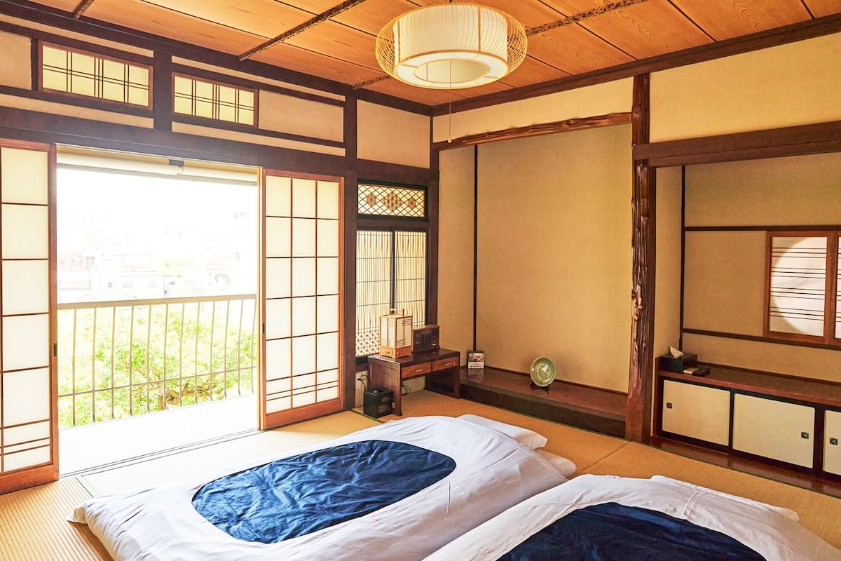 Une pièce de style japonais traditionnel, avec un sol recouvert de tatamis, des paravents shoji et une porte coulissante.