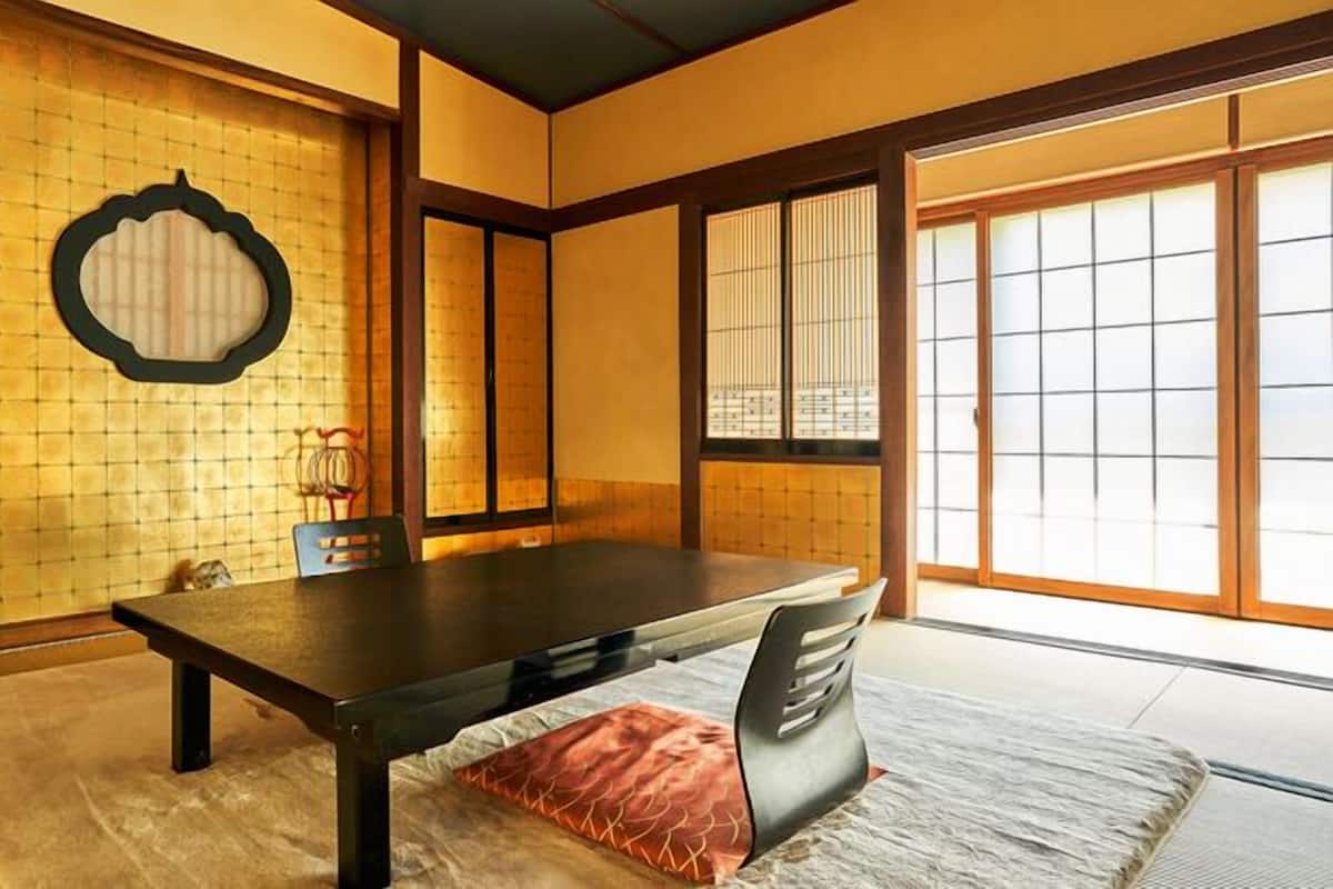 Une pièce de style japonais traditionnel, avec un sol recouvert de tatamis, une table basse et des portes coulissantes.