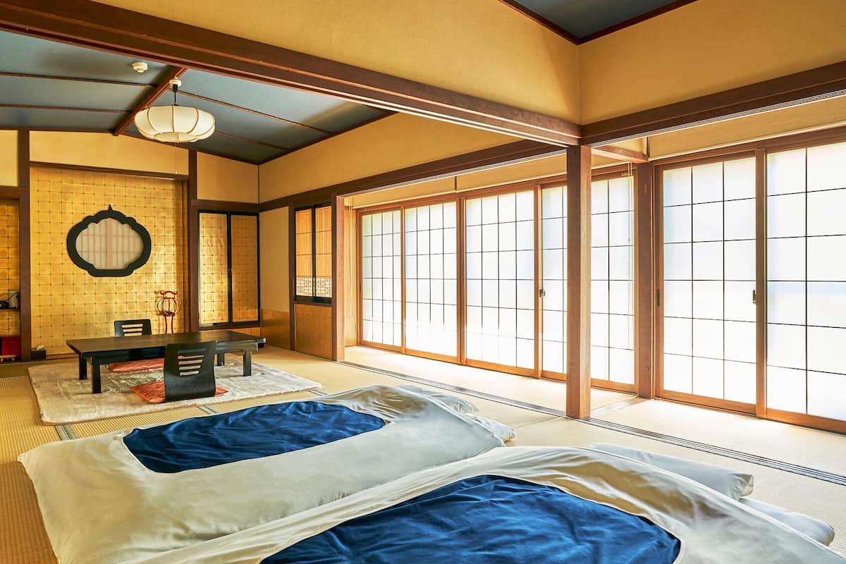 Une pièce de style japonais traditionnel, avec un sol recouvert de tatamis, une table basse et des portes coulissantes.