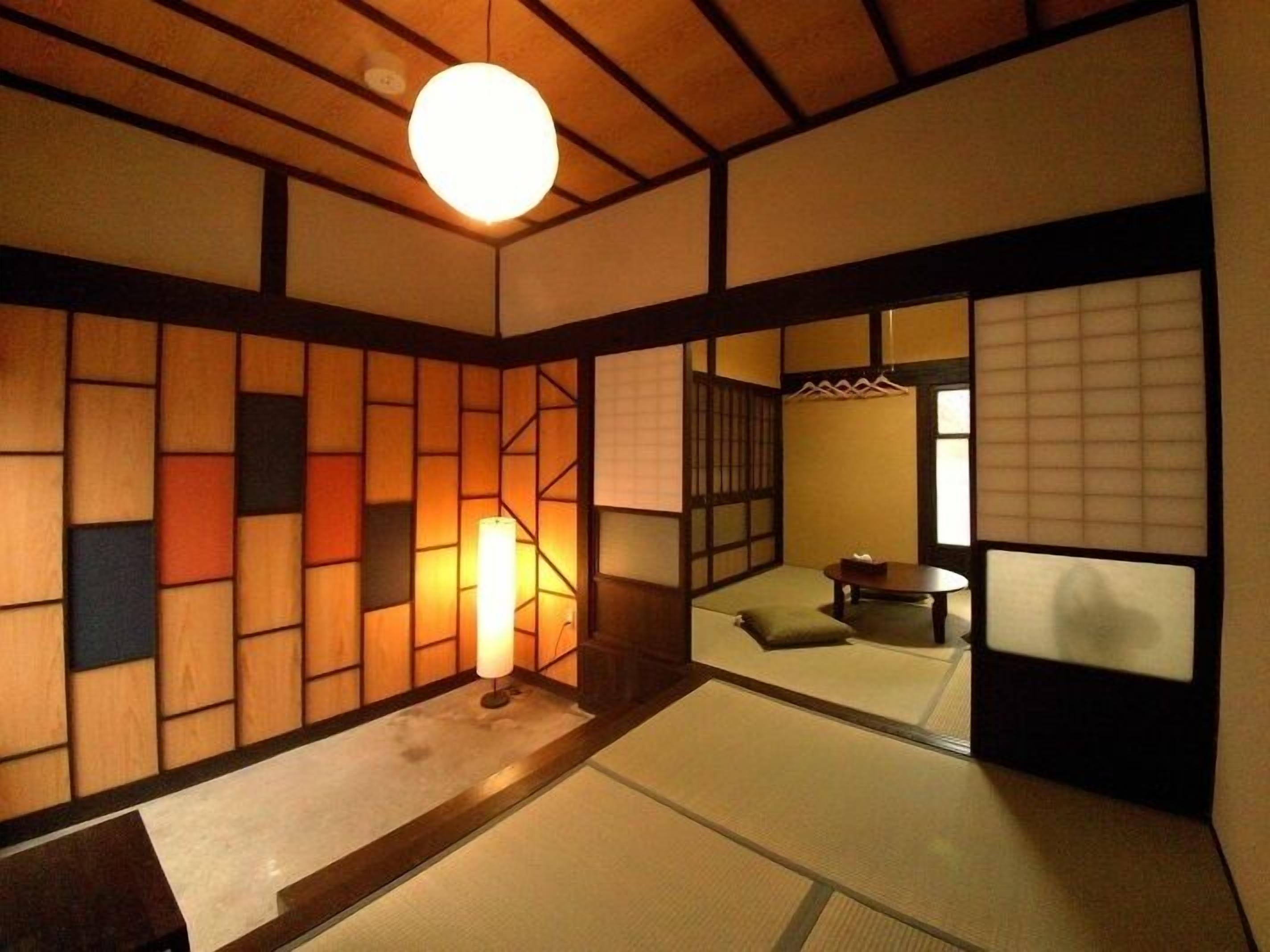 Ein traditioneller japanischer Raum mit Tatami-Bodenbelag, Shoji-Schirm und einer hängenden Leuchte.