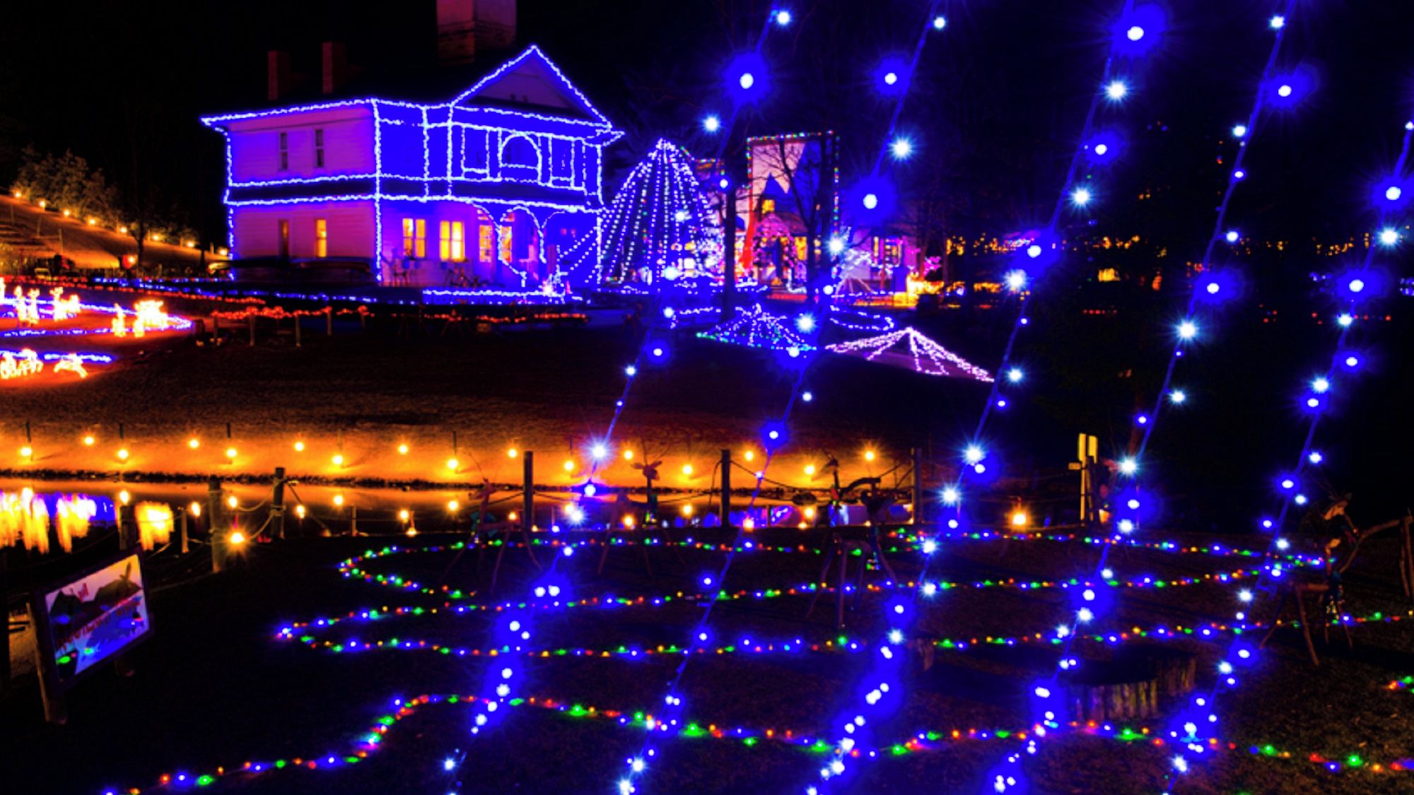 A building with illuminated outlines and a water feature with lights.