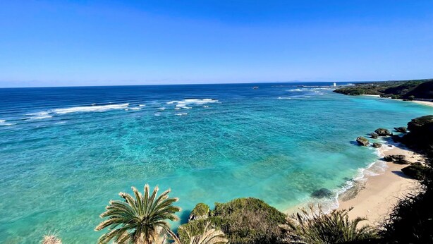 A coastal view with clear turquoise waters, a sandy beach, and rocky outcrops. - Sea Turtle View Cottage (Wadomari)