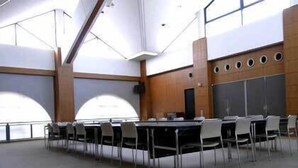 A conference room with a long table, chairs, and a large window. - Ono Himawari Hotel (Ono)