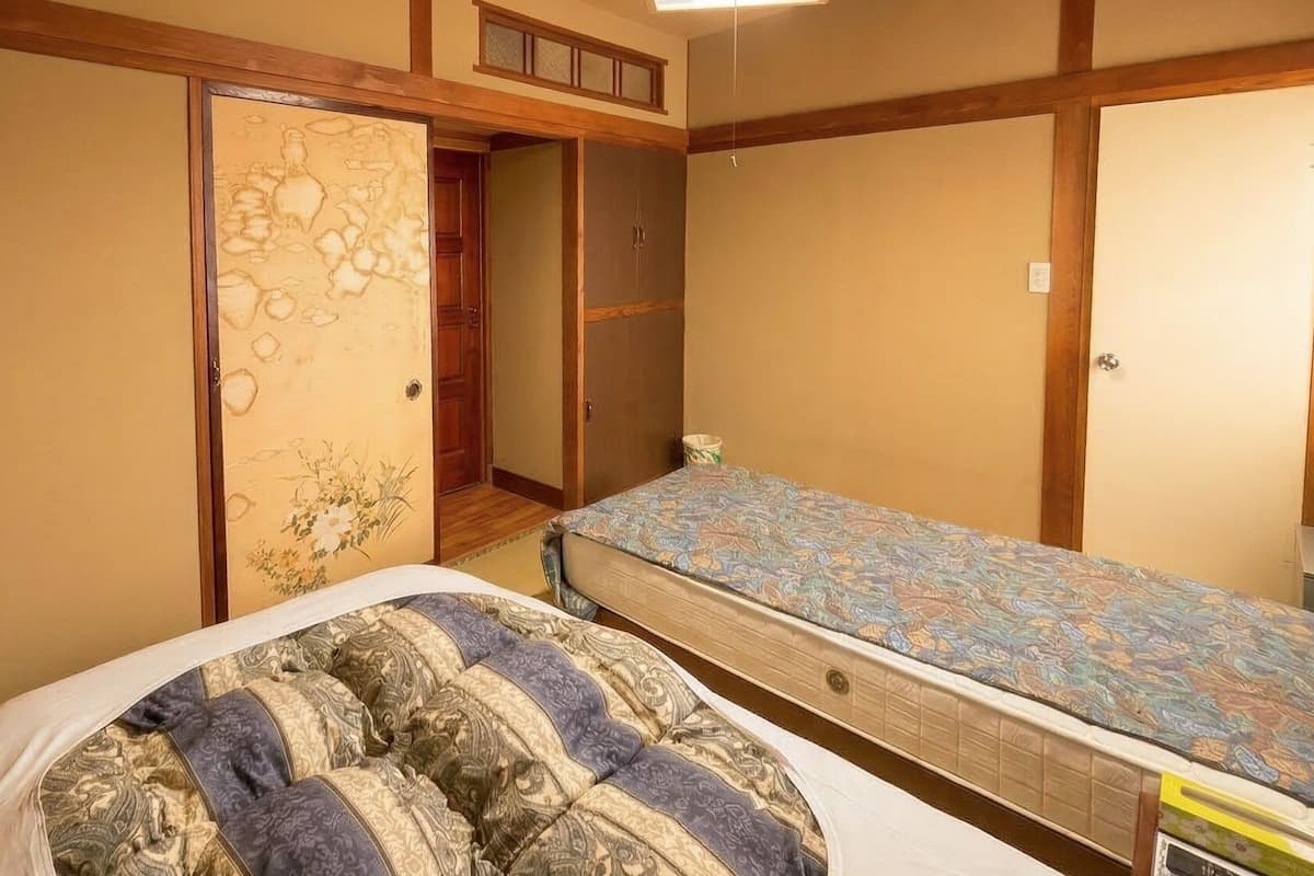 Um quarto com uma cama, um guarda-roupa e uma pequena mesa.