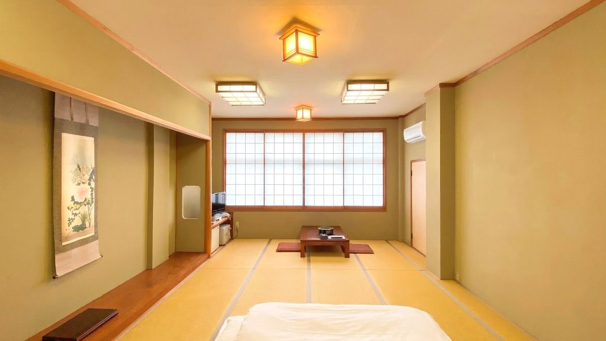 Perinteinen japanilainen huone, jossa on tatamimatto, futon-patja, liukuovet ja shoji-paperi-ikkuna.