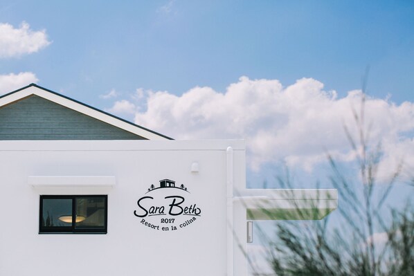 A white building with a sign that reads "Sara Beth 2017 Resort en la colina". - United Resort Sarabeth (Onna)