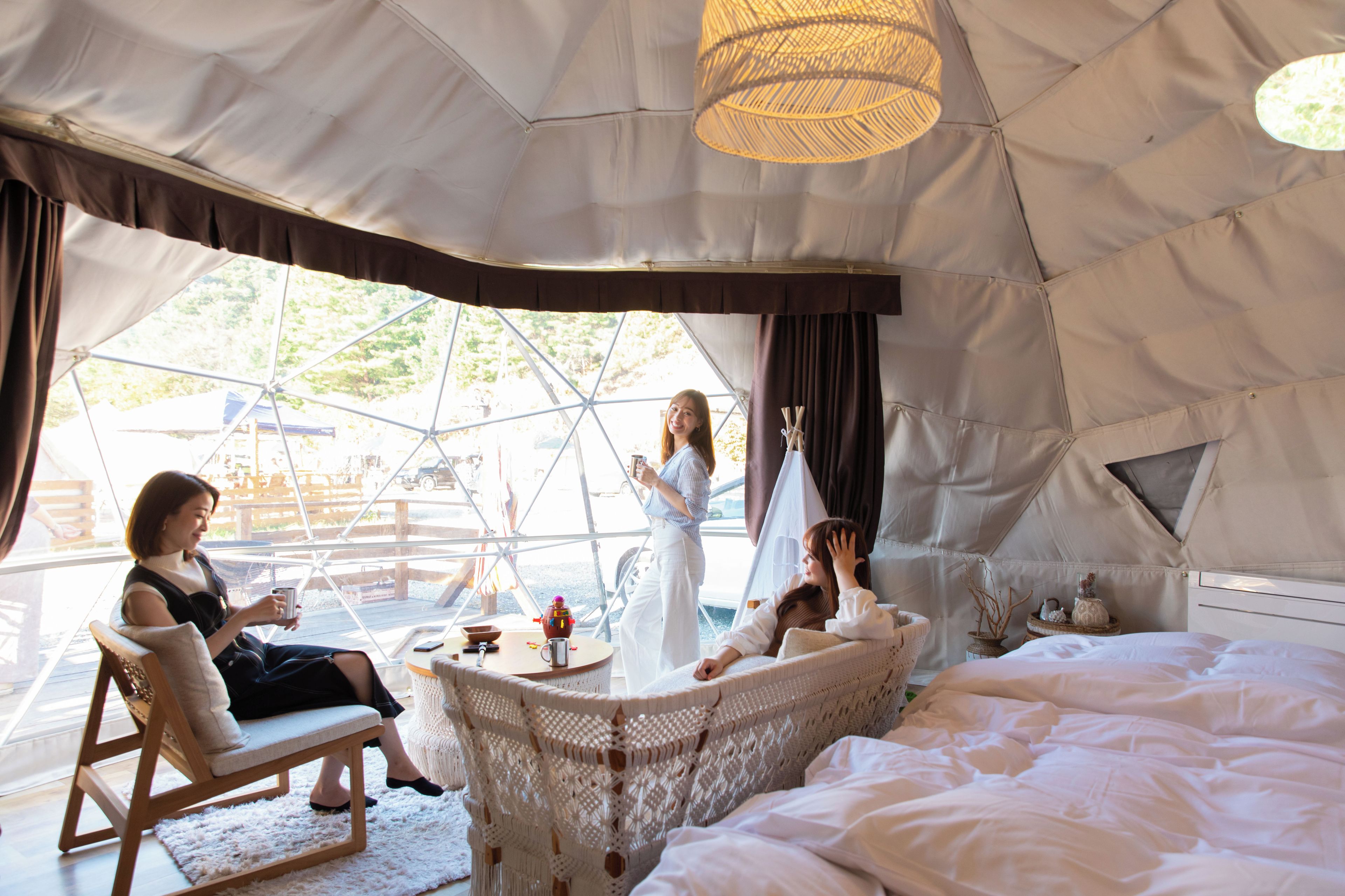 Alojamiento tipo tienda con cama, zona de estar y vistas al exterior.