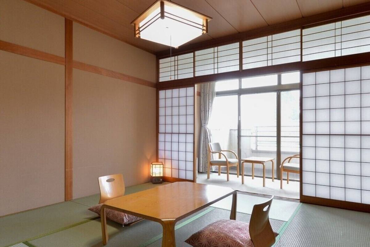 A traditional Japanese room with tatami flooring, a low wooden table, and sliding shoji doors.