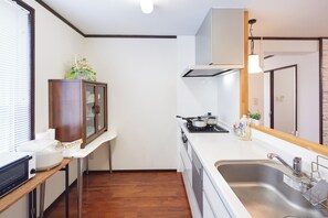Una cocina compacta con estufa, pileta y un armario de madera.
