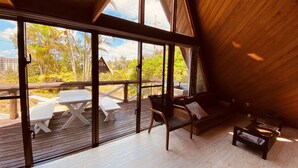 Un'ampia stanza con grandi finestre, un soffitto in legno e vista sull'esterno.