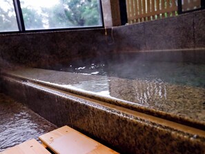 A hot spring bath with a wooden bench in front. - Atami Kaiun (Atami)