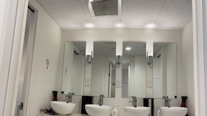 A bathroom with three white sinks, a large mirror, and a ceiling vent. - 54 Journey Tokyo Akasaka (Tokyo)