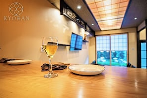 A table with a glass of white wine, a plate, and a napkin. - Kyoran-gengetsu (Kyoto)